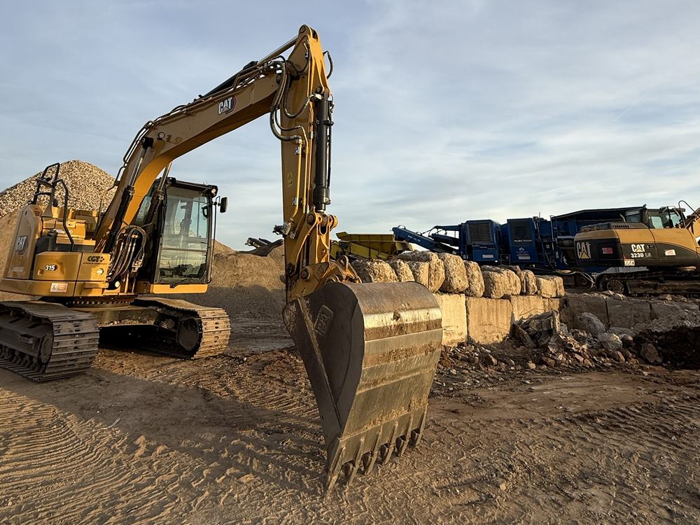 Escavatore CAT 315 con la benna appoggiata a terra