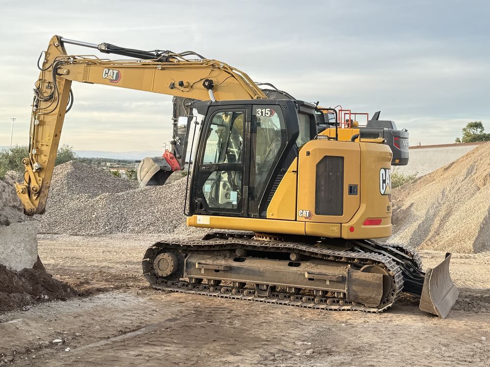Escavatore CAT 315 al lavoro su un cumulo di materiale