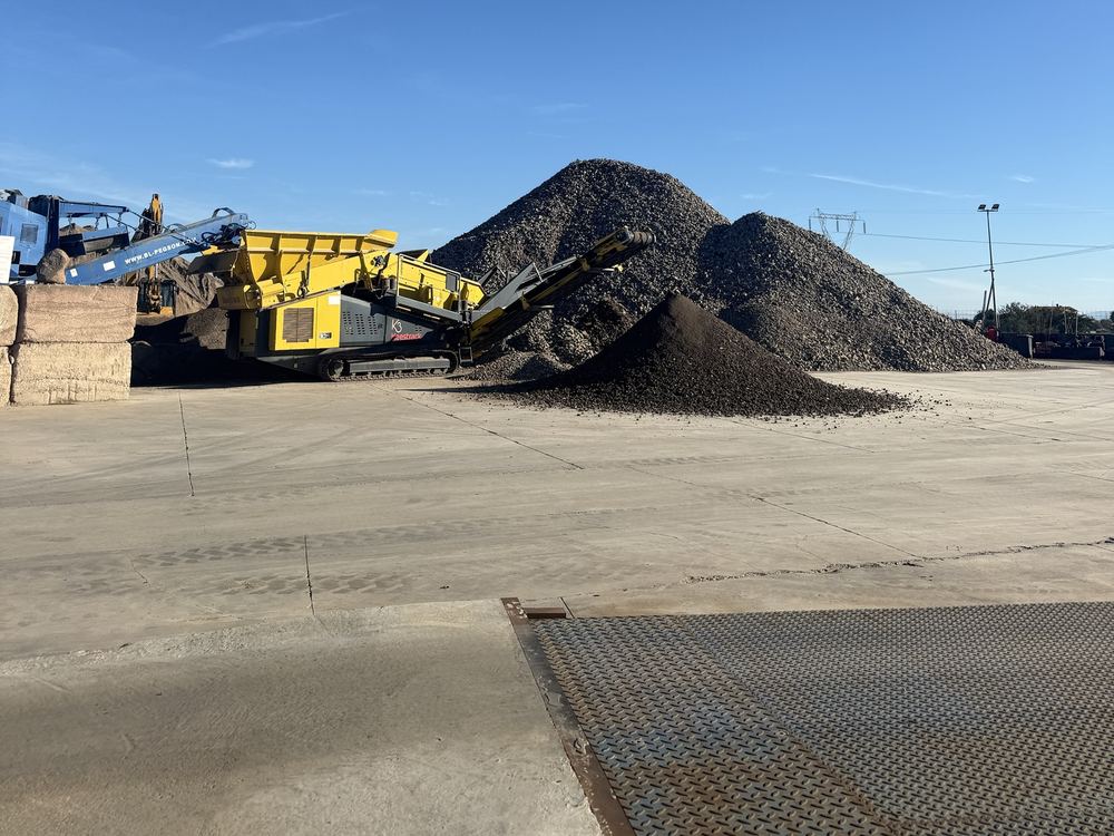 Vaglio mobile giallo e cumuli di materiale lavorato
