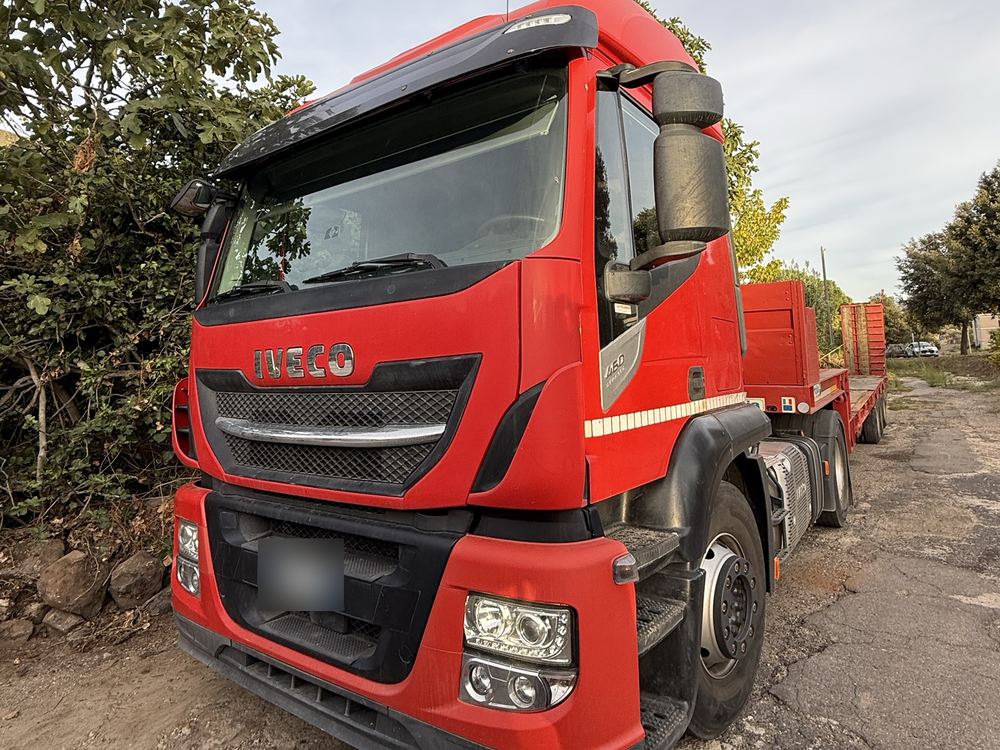 Trattore Iveco rosso con semirimorchio ribassato