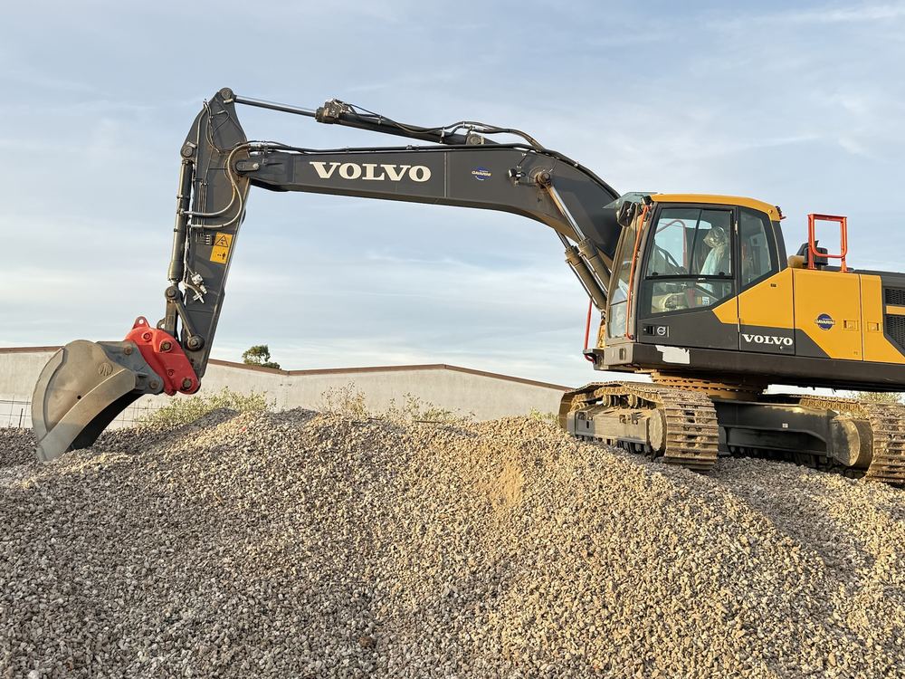 Escavatore Volvo con il braccio steso sul cumulo di ghiaia